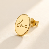 Custom Handwriting Oval Stud Earrings detail photo - close-up of gold oval stud engraved with handwritten love Anthology Jewelry