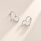 Custom Heart-Frame Name Stud Earrings silver variant hero on pale ivory background - Anthology Jewelry