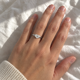 Custom Heart Signet Initial Ring in silver with M personalization, casual phone-style worn view on white bedding - Anthology Jewelry