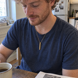 Gold medium column necklace worn in a casual kitchen photo