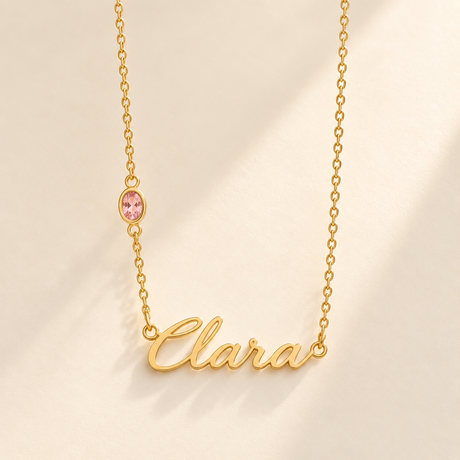 Gold script Clara necklace with one October-pink stone integrated on left chain