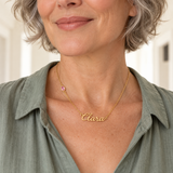 Woman in sage blouse wearing script name birthstone necklace