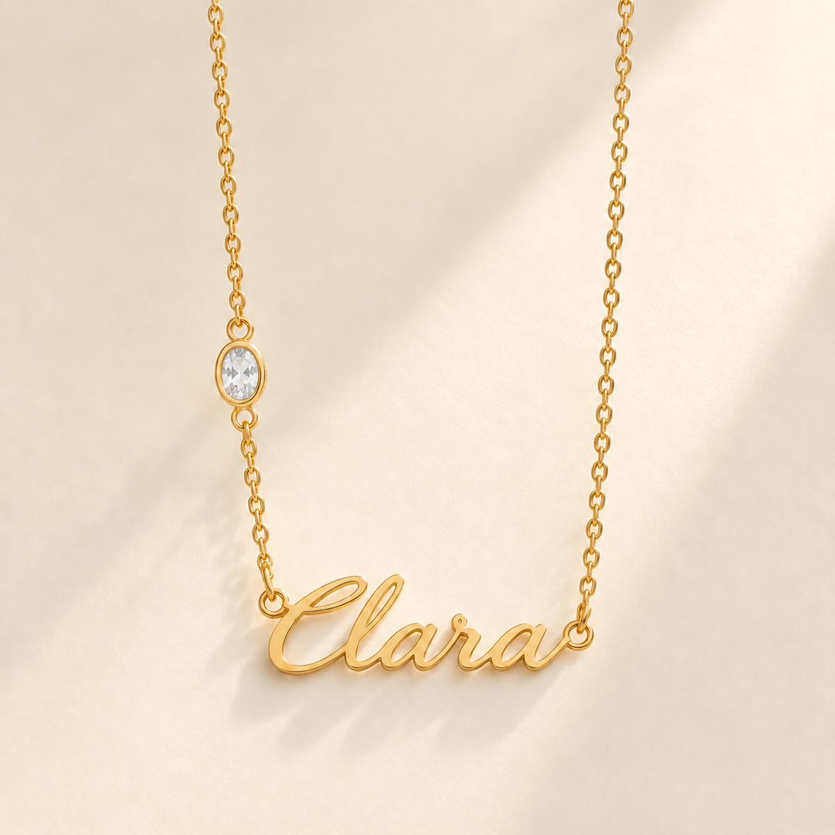 Gold script Clara necklace with april birthstone-color stone on left chain