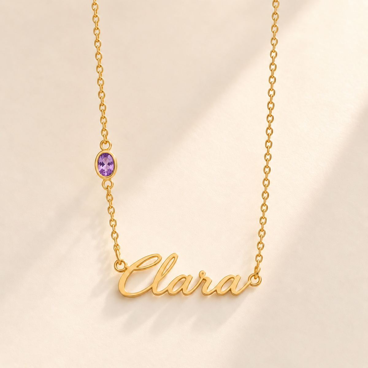 Gold script Clara necklace with february birthstone-color stone on left chain
