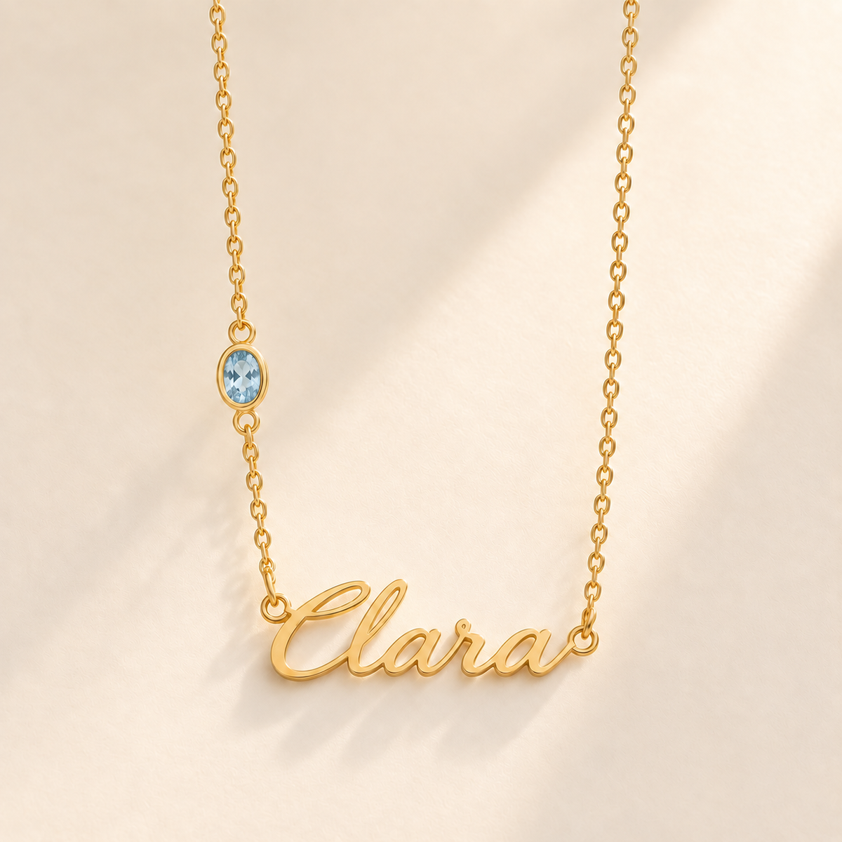 Gold script Clara necklace with march birthstone-color stone on left chain