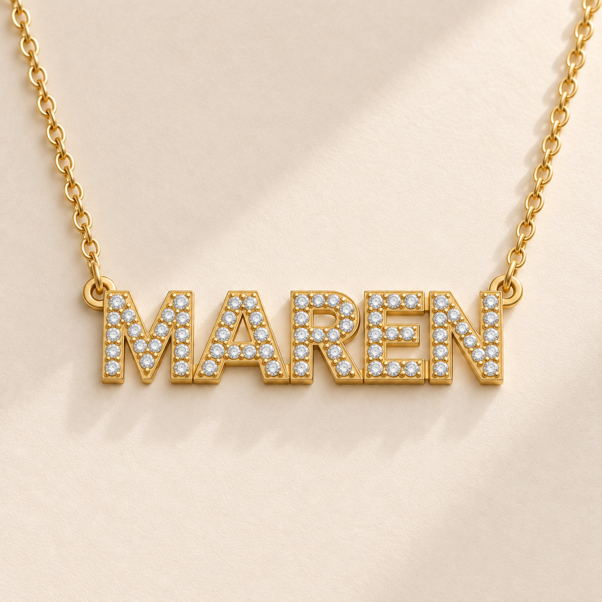 Gold custom pavé name necklace macro showing CZ block letters and side eyelets