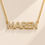 Gold custom pavé name necklace macro showing CZ block letters and side eyelets