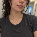 Customer phone photo wearing a silver NORA pavé name necklace
