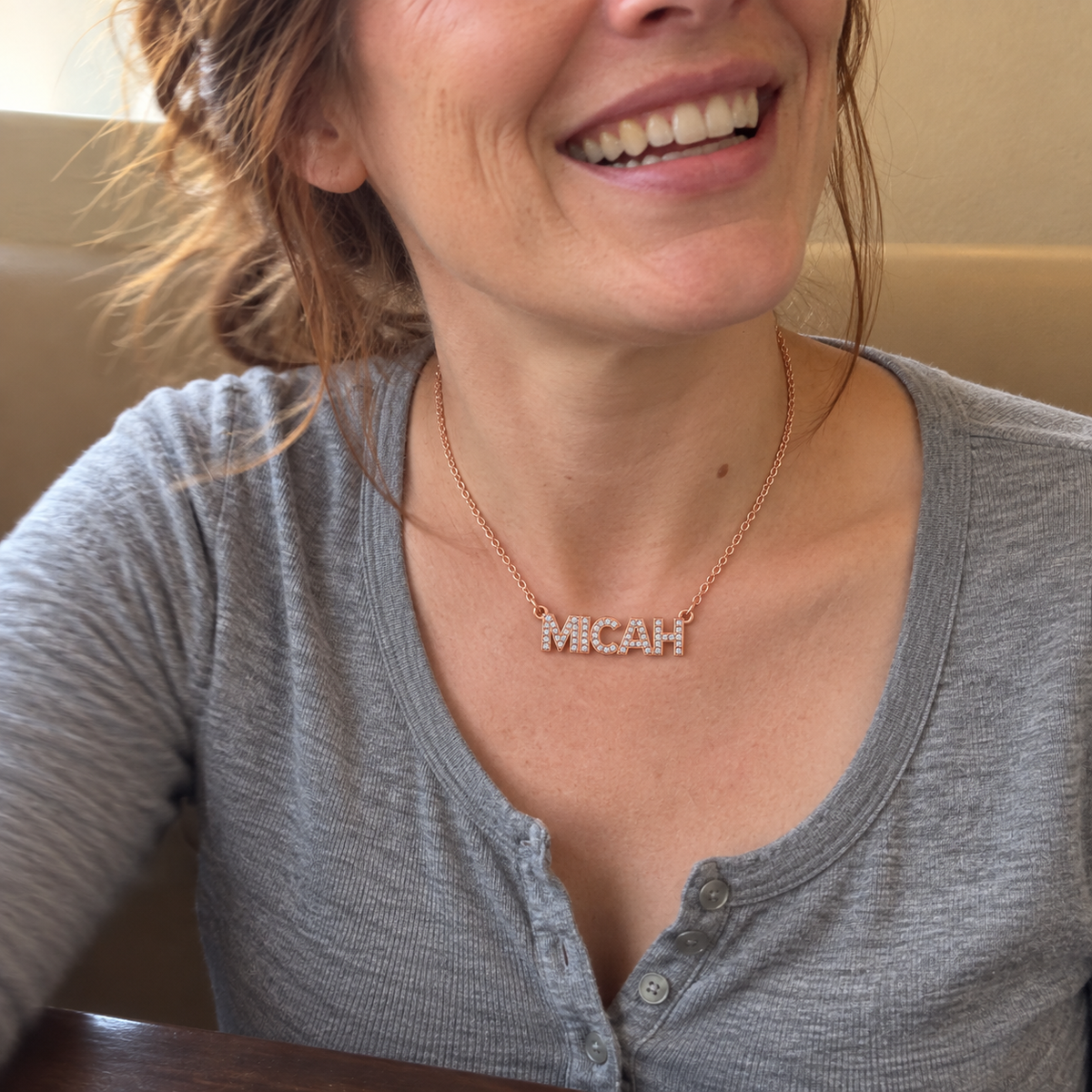 Customer phone photo wearing a rose gold MICAH pavé name necklace