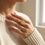 Custom Photo Locket Ring professional lifestyle photo - hand resting on a cream knit sweater wearing gold oval hinged locket ring Anthology Jewelry