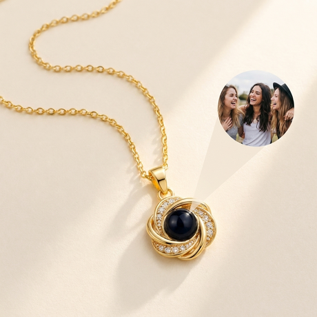 Custom Photo Necklace Swirl Knot Pendant hero photo - gold love-knot pendant with photo projection stone on cream background Anthology Jewelry