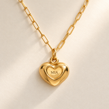 Custom Puffy Heart Necklace hero photo - gold heart with MIA engraving and soft consistent diagonal light Anthology Jewelry