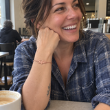Custom Script Name Bracelet in rose gold with Sofia personalization, worn at a cafe; illustrative phone-style marketing image - Anthology Jewelry