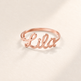 Custom Script Name Ring hero photo - rose gold ring with a cutout cursive name across the front Anthology Jewelry