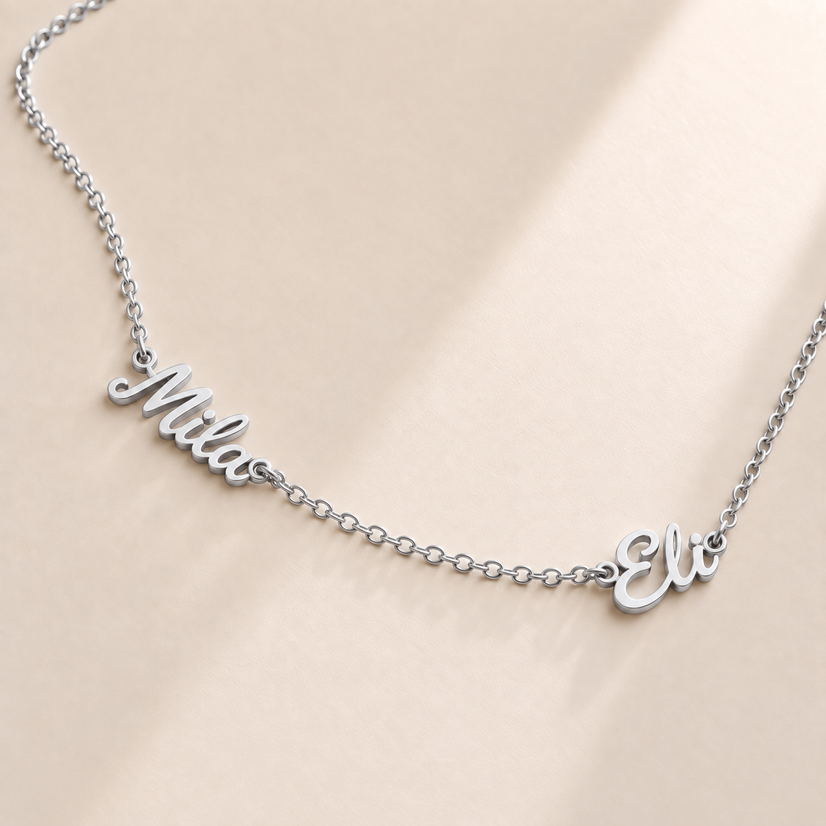 Custom Spaced Names Necklace hero photo - two connected script names on a silver rolo chain Anthology Jewelry