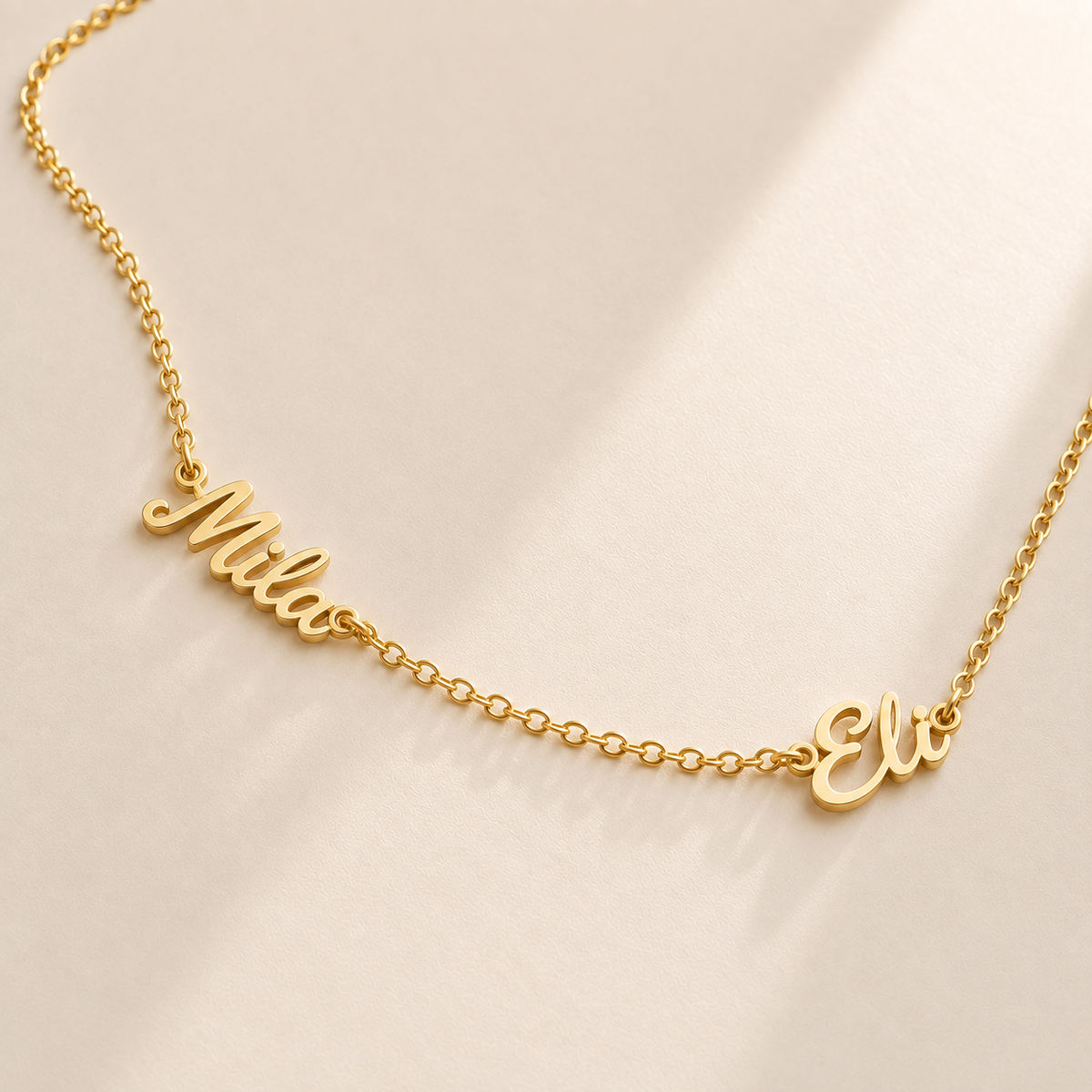 Custom Spaced Names Necklace hero photo - two connected script names along one gold rolo chain Anthology Jewelry