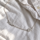 Custom Spaced Names Necklace UGC-style photo - silver finish with Ava / Leo personalization Anthology Jewelry