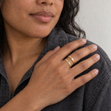 Custom Thin Double Ring lifestyle photo - woman in dark shirt wearing gold double band ring Anthology Jewelry