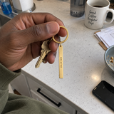Casual phone photo of a custom vertical bar keychain by keys on a kitchen counter