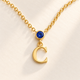 Custom Vertical Birthstone Initial Necklace macro detail photo - complete gold serif C pendant with September blue round gemstone and bezel Anthology Jewelry