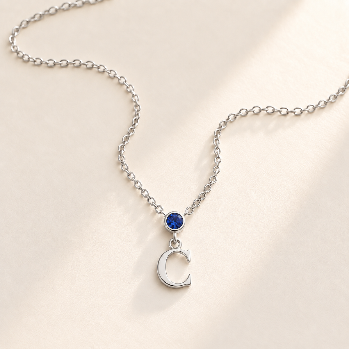 Silver vertical birthstone initial necklace with blue stone