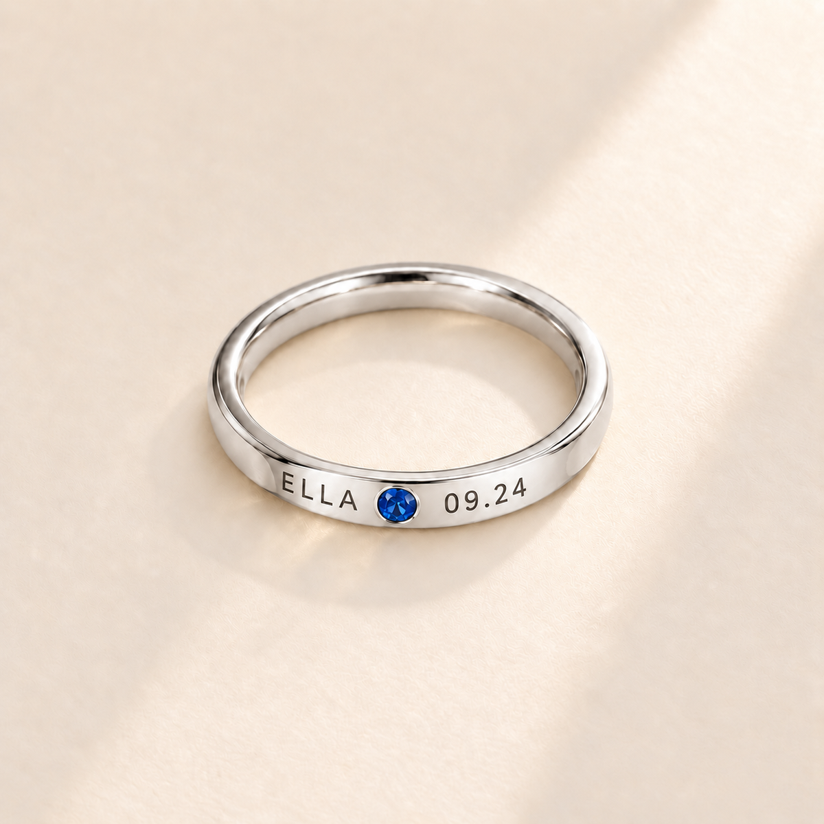 Custom Date & Name Birthstone Stacking Ring Silver hero photo - ELLA and 09.24 engraving beside a blue birthstone Anthology Jewelry