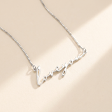 "Loveyou" Necklace hero photo - sterling silver script cutout pendant on cream background Anthology Jewelry